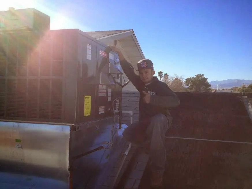 HVAC technician performing Heat Pump Repair on a rooftop unit in Charlottesville